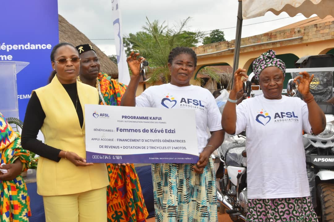 Mme AVOCEVOU, remettant le chèque symbolique aux femmes bénéficiaires du Programme KAFUI...